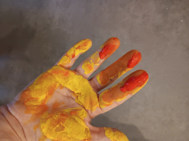 Handinnenfläche, gelb angemalt, mit roten Fingerspitzen Handinnenfläche, gelb angemalt, mit roten Fingerspitzen